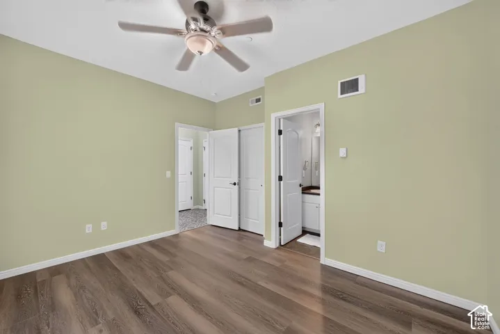 Interior space featuring wood-finish flooring, a ceiling fan with integrated lighting, and white six-panel doors