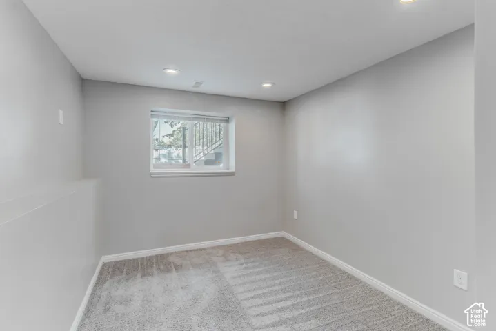 Neutral-toned interior space featuring light gray wall paint, gray carpeting, and recessed lighting