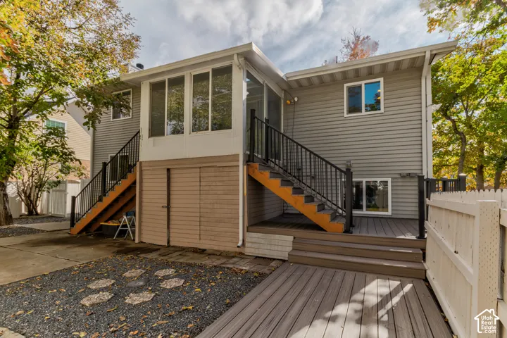 Exterior featuring horizontal siding, a screened porch, dual staircases with metal railings, and a multi-level composite deck
