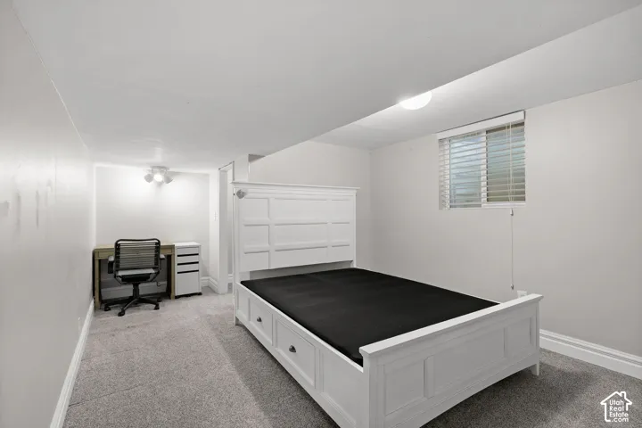 Neutral-toned interior featuring wall-to-wall carpeting, recessed ceiling lighting, and a single-pane window with horizontal blinds