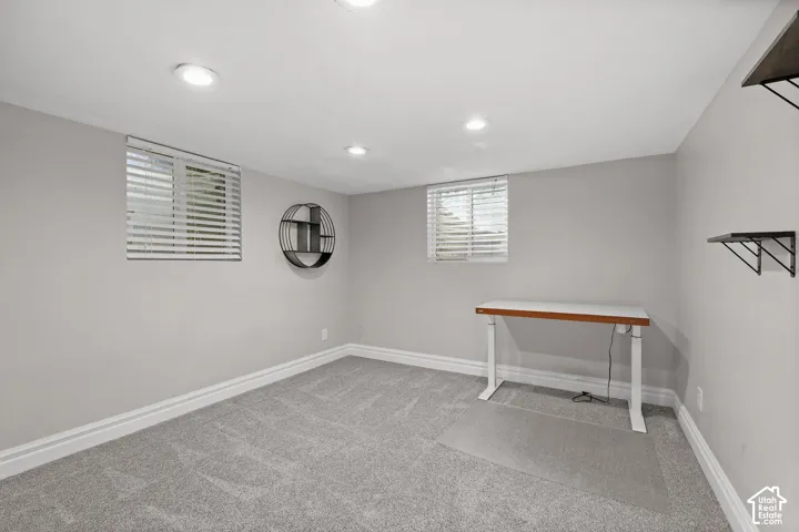 Neutral-toned room featuring recessed lighting, wall-to-wall carpeting, and two windows equipped with horizontal blinds