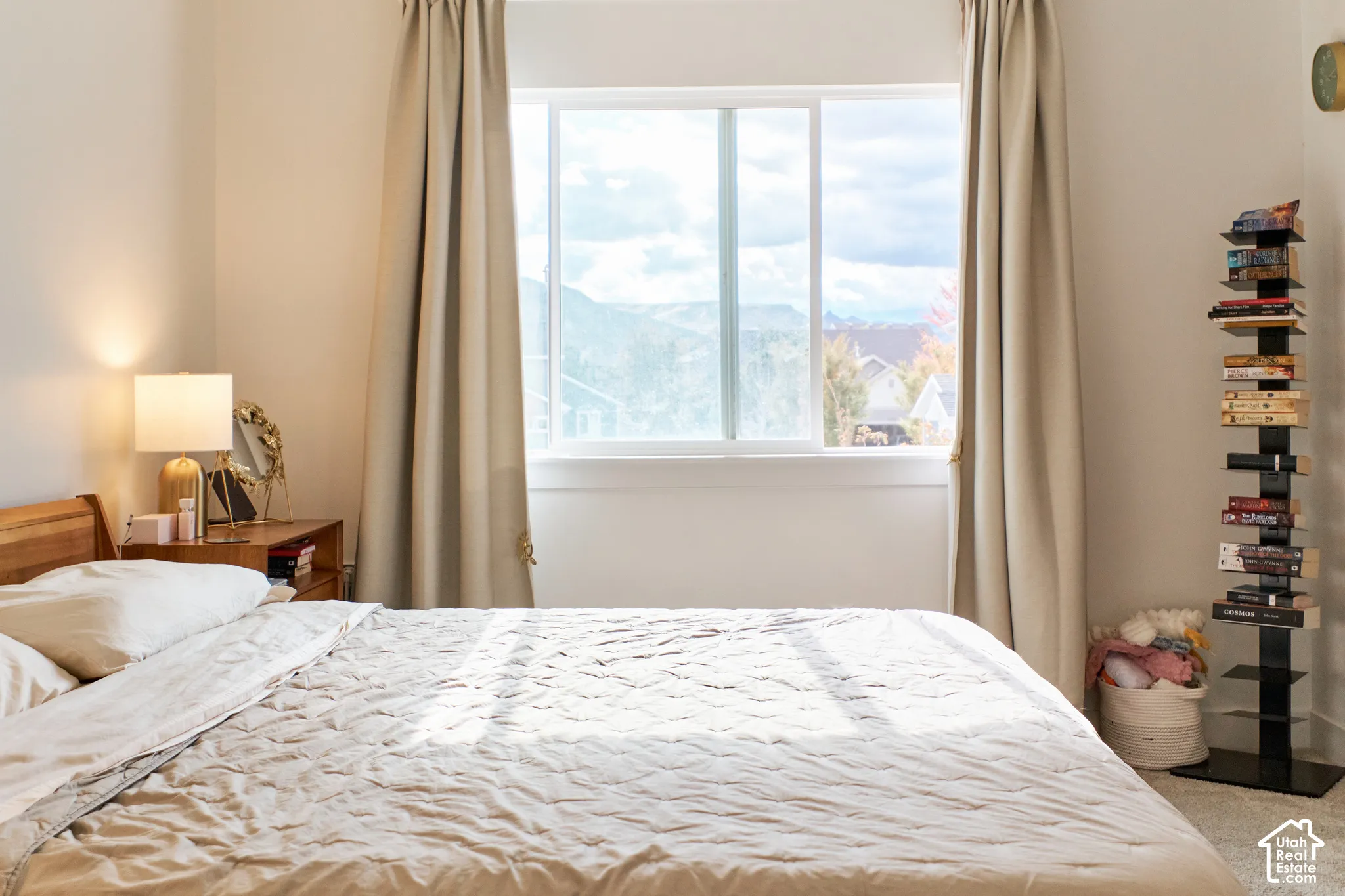 Large window featuring exterior mountain and landscape scenery, neutral wall paint, and carpeted flooring