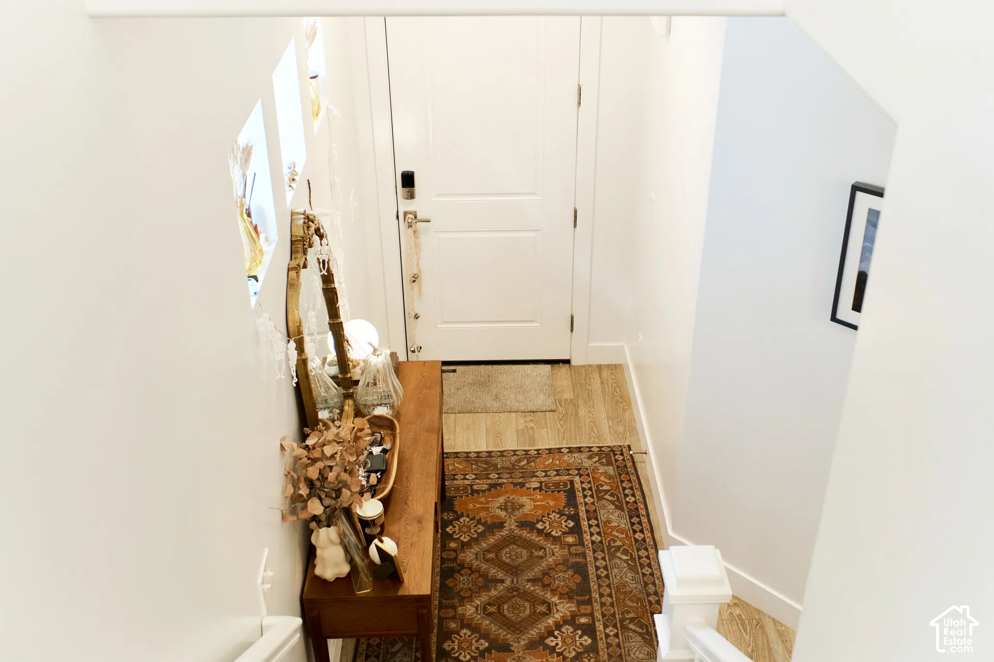 Entryway featuring a solid panel front door, wood-finish flooring, and integrated wall niches