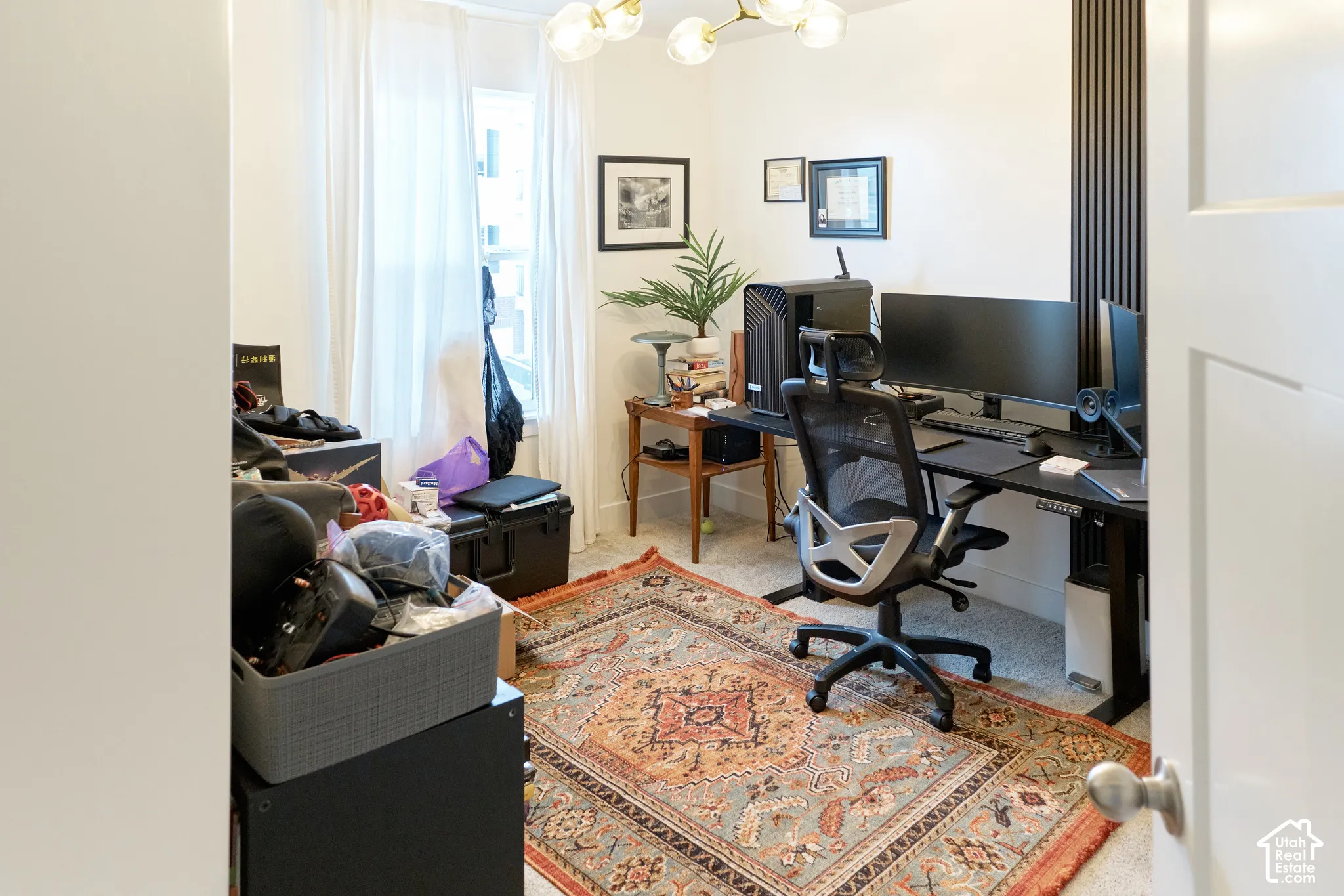 Room featuring vertical slat wall detailing, a multi-arm modern light fixture, and neutral-toned wall-to-wall carpeting