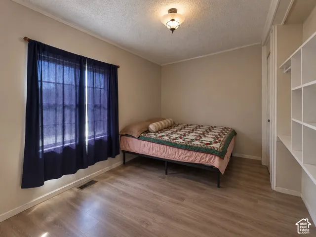 Wood-finish flooring, built-in shelving, multi-pane window, and flush-mount ceiling light fixture