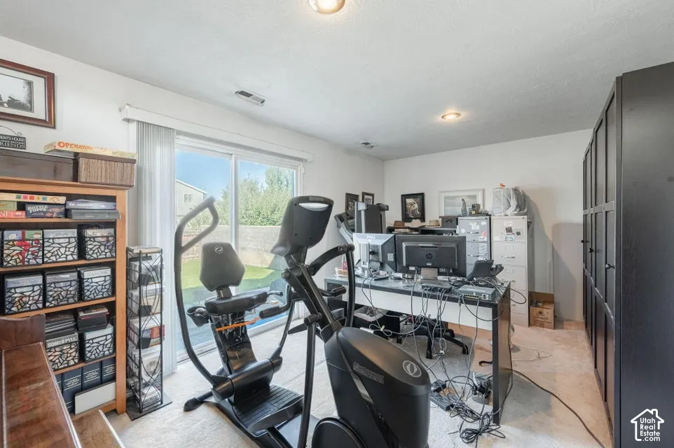 Room featuring recessed lighting, a sliding glass door with vertical blinds, and a built-in black storage unit
