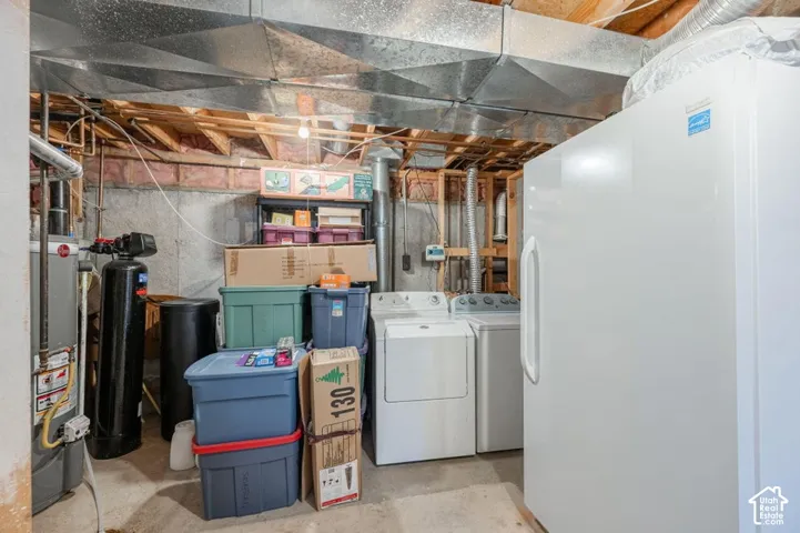 Mechanical area featuring a water heater, water softener system, laundry hookups, and exposed wood joists with metal ductwork