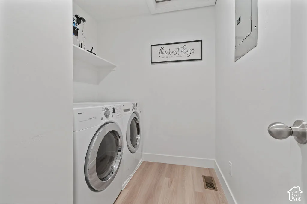 Laundry space featuring wood-finish flooring and a built-in shelving unit