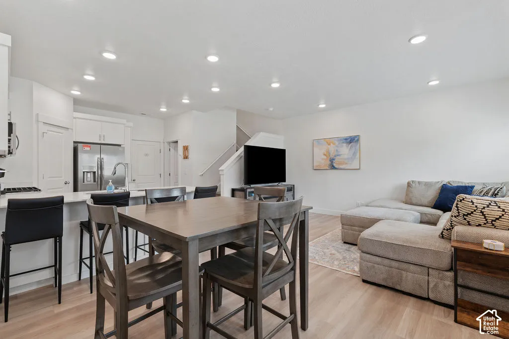 Open-concept kitchen and living area featuring wood-finish flooring, recessed lighting, and a kitchen island with stone-surface countertops