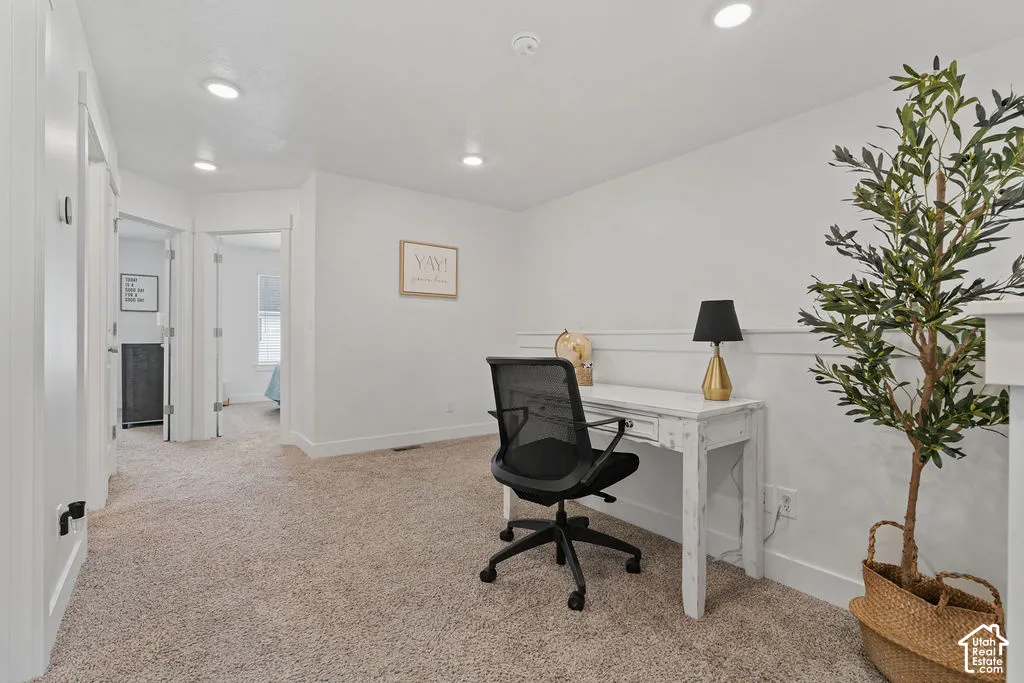 Neutral-toned wall-to-wall carpeting, recessed ceiling lighting, and decorative wall molding