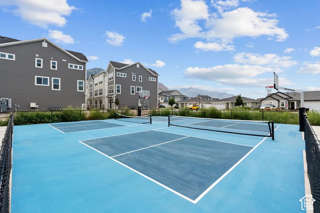 Community recreation area featuring multiple pickleball courts, basketball hoop, and mountain backdrop