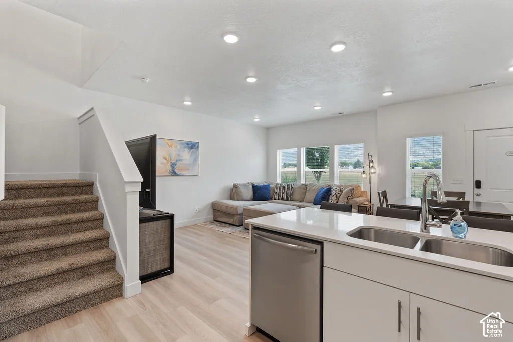 Open-concept kitchen featuring a stainless steel undermount sink, quartz countertops, and recessed lighting throughout