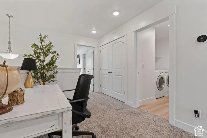 Neutral-toned carpeting, recessed ceiling lighting, double-panel interior doors, and dedicated laundry area with wood-finish flooring