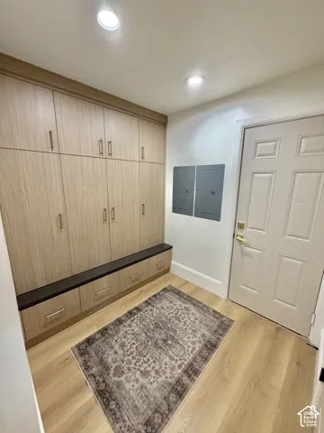 Built-in cabinetry with wood-finish doors, integrated bench seating, metallic hardware, and wood-finish flooring