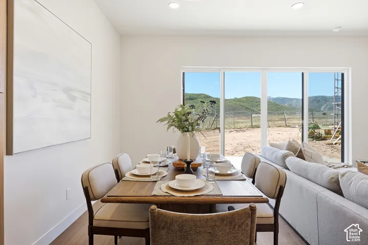 Interior space featuring wood-finish flooring, recessed lighting, and large sliding glass doors showcasing mountain scenery