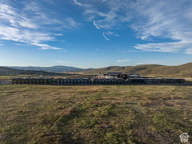 Aerial perspective of multiple multi-story structures featuring metal-roofed exteriors, set against an expansive landscape with mountain range backdrops