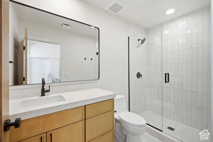 Bathroom featuring a vanity with a light wood finish, white countertop with grey veining, integrated sink, and matte black hardware