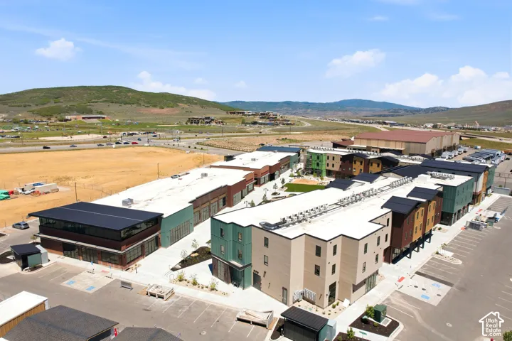 Multi-building complex featuring contemporary architectural design, exterior metal and masonry cladding, flat roofing systems, paved surface parking, and curated landscaped grounds