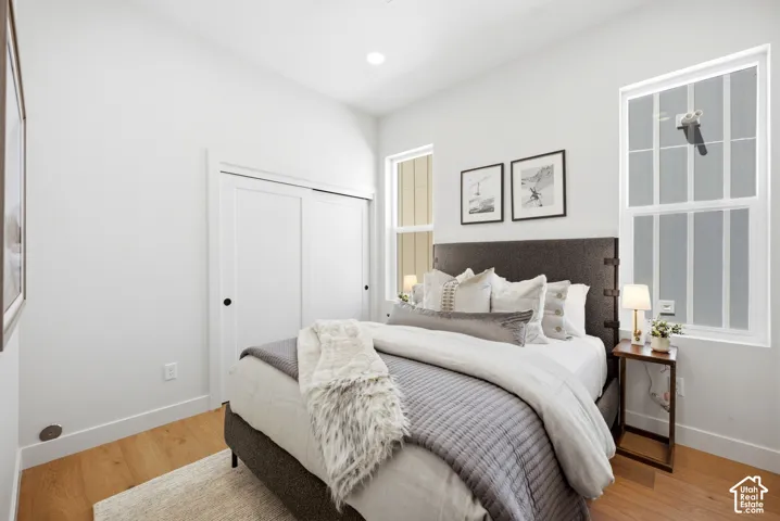 Neutral walls, wood-finish flooring, sliding closet doors, and multi-pane windows with recessed lighting