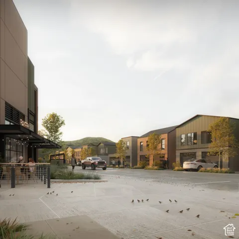 Multi-use complex featuring industrial-style architecture, metal siding, brick masonry, concrete paving, and mountain backdrop