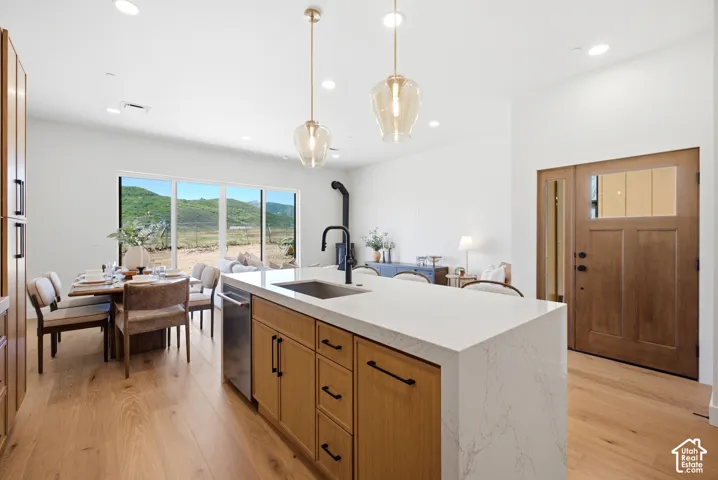 Kitchen island featuring a waterfall-edge countertop, undermount sink, and matte black faucet