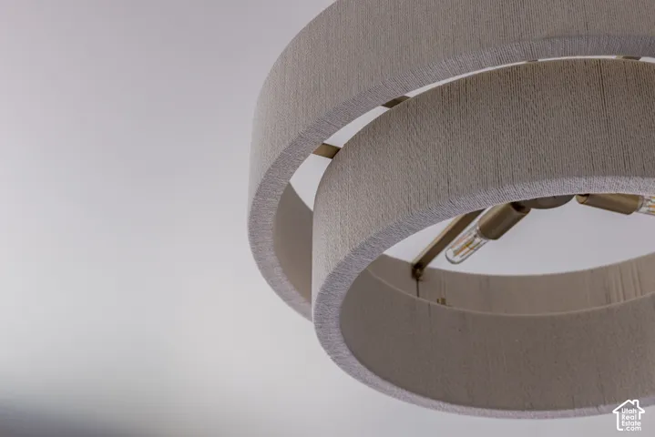 Multi-tiered drum light fixture featuring textured off-white fabric shades and a metallic brass finish frame