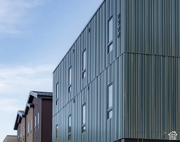 Modern architectural exterior featuring vertical metal panel siding, clean lines, and tall rectangular windows