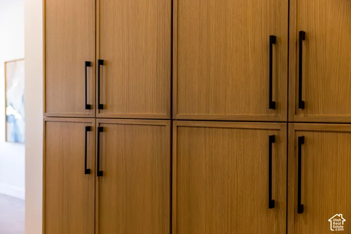 Built-in floor-to-ceiling cabinetry with wood-finish doors and matte black vertical hardware