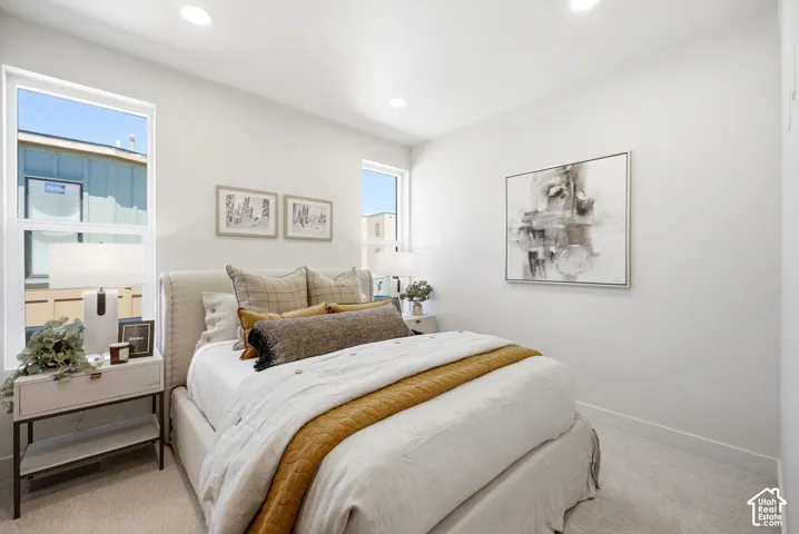 Neutral-toned interior featuring dual vertical windows, recessed ceiling lighting, and wall-to-wall carpeting
