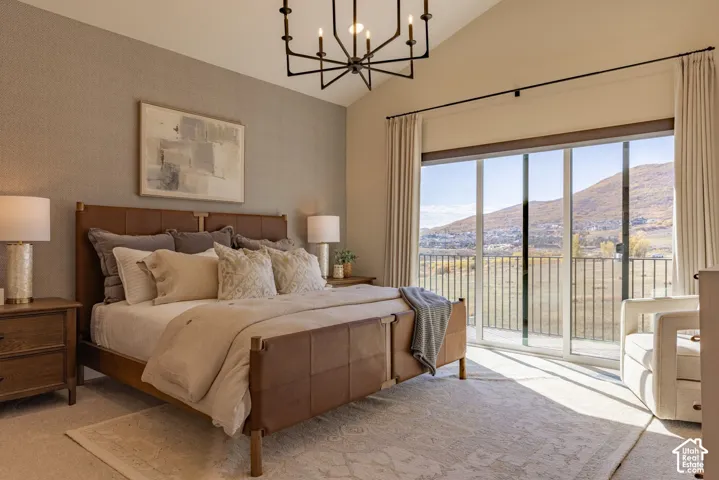Vaulted ceiling featuring a matte black chandelier and glass sliding doors revealing a mountainous landscape