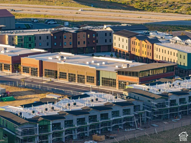 Multi-story commercial complex featuring brick and metal siding, expansive storefront glass, flat roofing systems, and dedicated asphalt parking areas