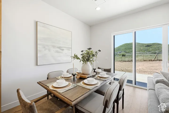 Room featuring wood-finish flooring, recessed lighting, and a sliding glass door providing natural light and mountainous scenery