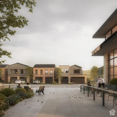 Mixed-use development featuring brick and metal-panel siding, multi-story commercial and residential architecture, integrated garage bays, and paved outdoor pedestrian plazas