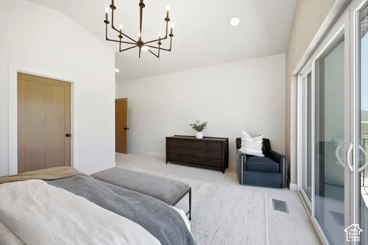 Vaulted ceilings, multi-arm chandelier, and sliding glass doors with direct exterior access