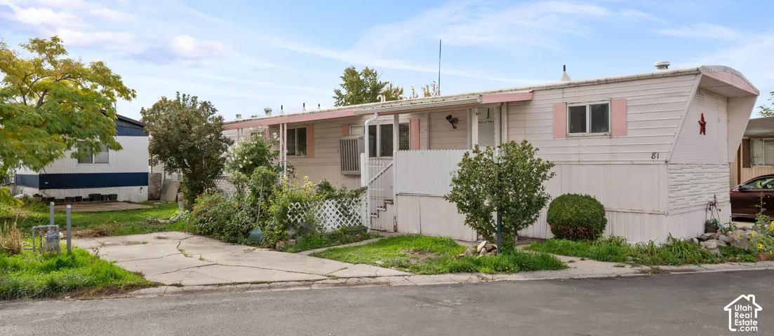 Exterior featuring horizontal siding, a covered porch, concrete driveway, and established landscape