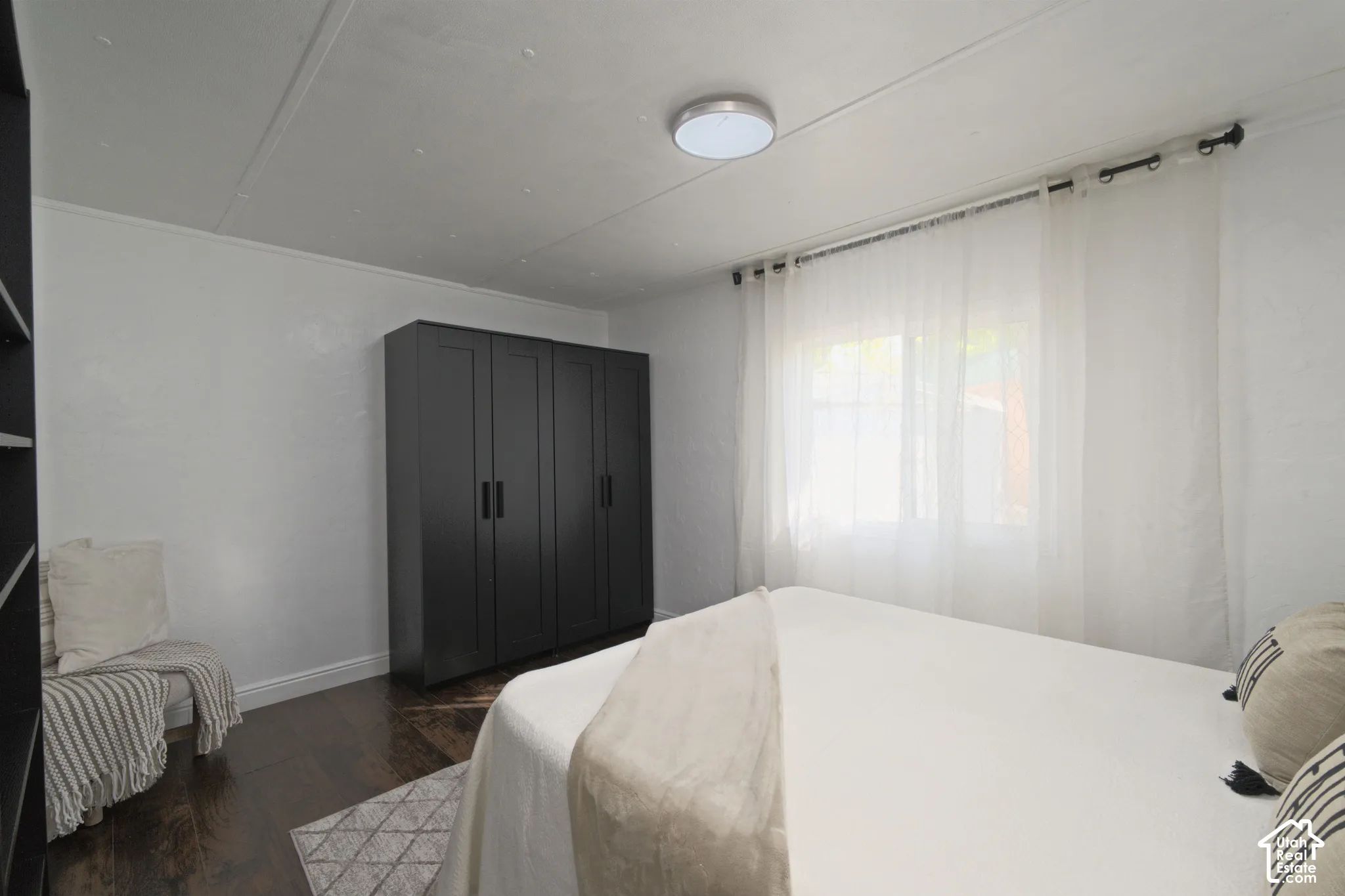 Room featuring wood-finish flooring, built-in matte black cabinetry, and a neutral palette