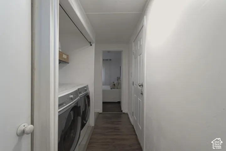 Laundry area featuring wood-finish flooring, white paneled interior doors, and a built-in closet rod