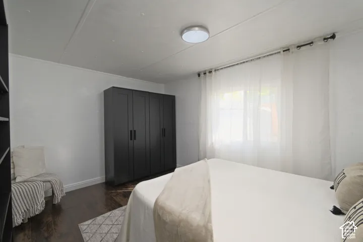 Room featuring wood-finish flooring, built-in matte black cabinetry, and a neutral palette