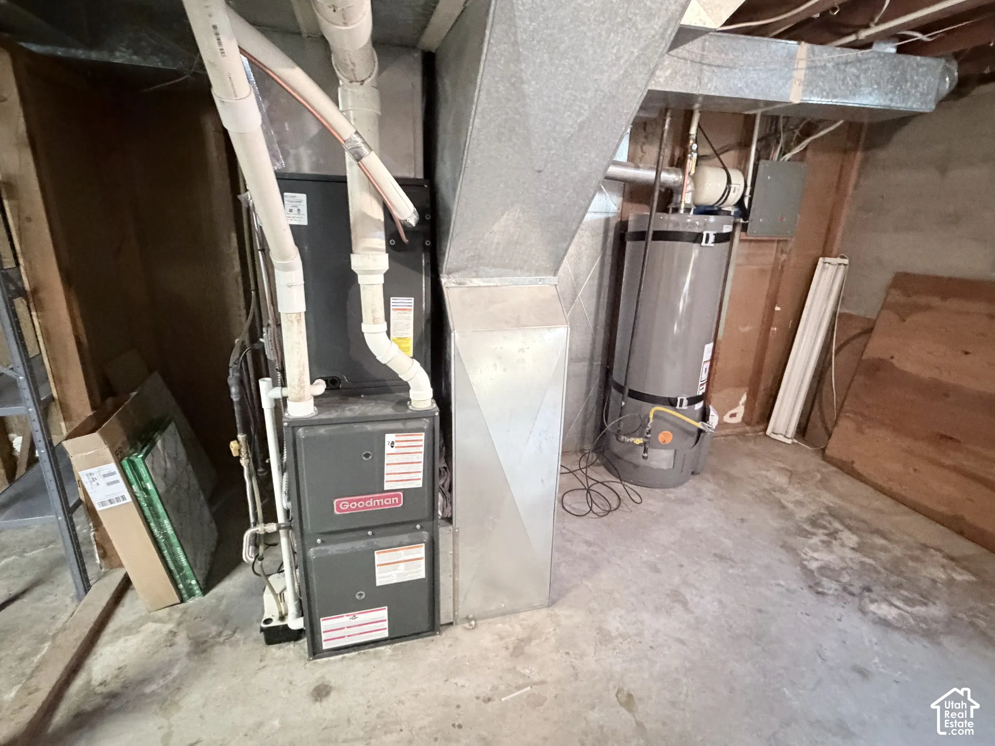 Utility area featuring a Goodman furnace, metallic ductwork, and a vertical water heater