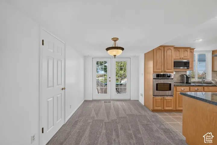 Kitchen featuring wood cabinetry, stainless steel built-in wall oven, built-in microwave, and dark countertops