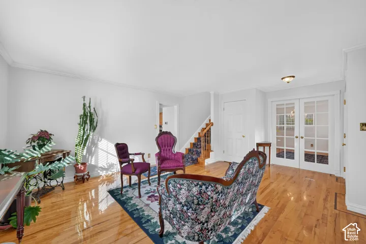 Hardwood flooring, French doors with glass panes, and a wooden staircase featuring decorative spindles
