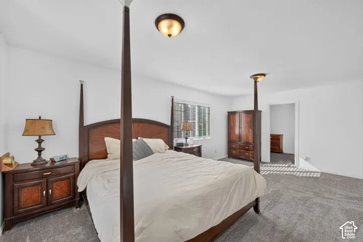 Neutral carpeting, dual semi-flush mount ceiling lighting, and windows featuring blinds