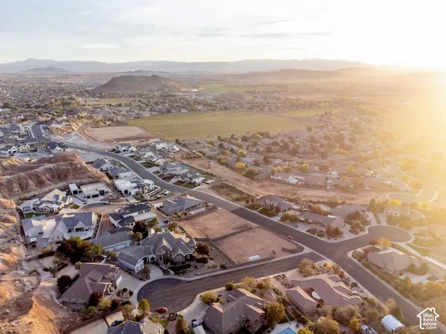 Aerial perspective of the residential area featuring a natural desert landscape backdrop, mountain terrain, and established road infrastructure
