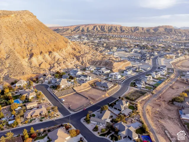 Aerial perspective showcasing a residential subdivision set against a backdrop of prominent rock formations and desert terrain
