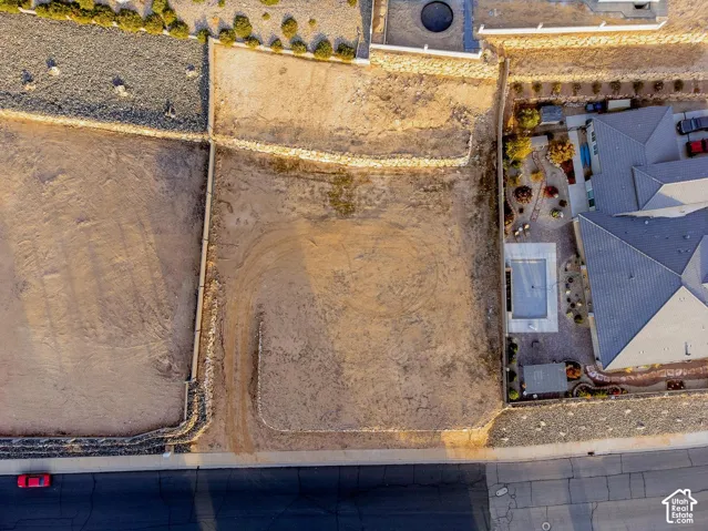Vacant residential lot featuring tiered stone retaining walls and perimeter fencing