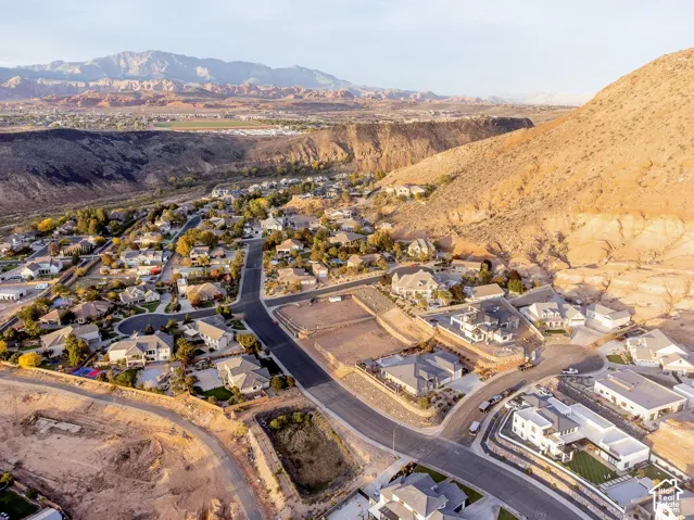 Aerial perspective of the residential development featuring paved street infrastructure and prominent mountain backdrop