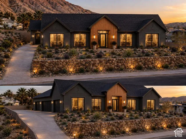 Exterior featuring a multi-gabled roofline, dark stucco siding, wood-paneled entryway, stacked stone retaining wall, and mountain backdrop