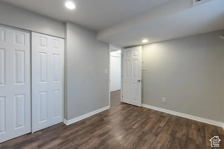 Room with wood-finish flooring, recessed lighting, and white six-panel interior doors