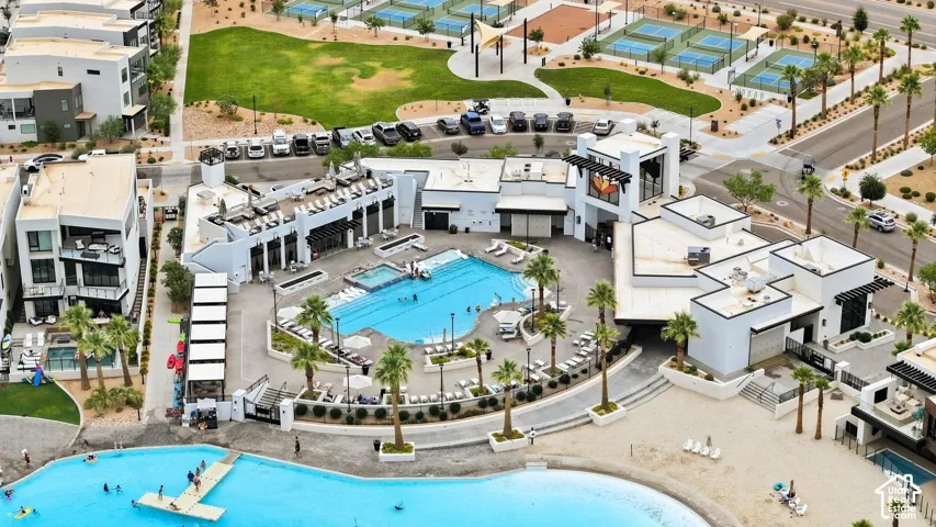 Community recreational facility featuring a swimming pool, integrated spa, surrounding hardscaped patio, and palm tree landscaping