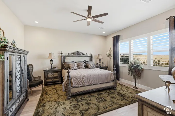 Room featuring wood-finish flooring, recessed lighting, a modern ceiling fan, and horizontal louvered interior window shutters